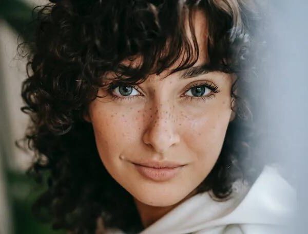 Junge Frau mit Sommersprossen und natürlicher Haut